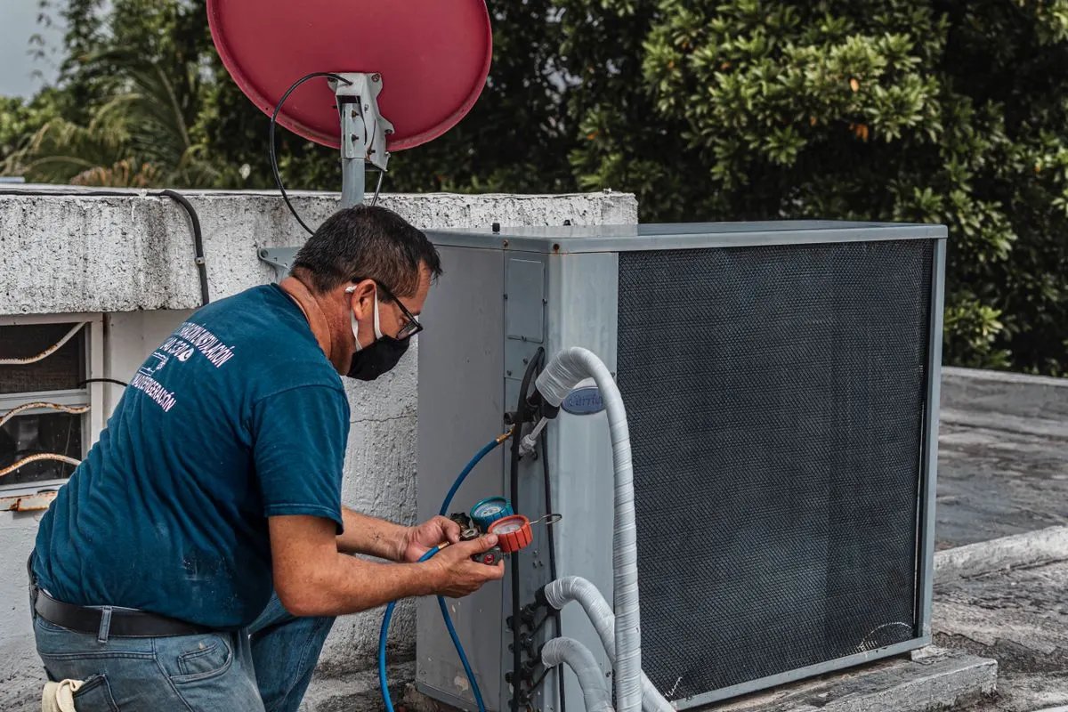 Técnico realizando limpeza e manutenção de ar-condicionado