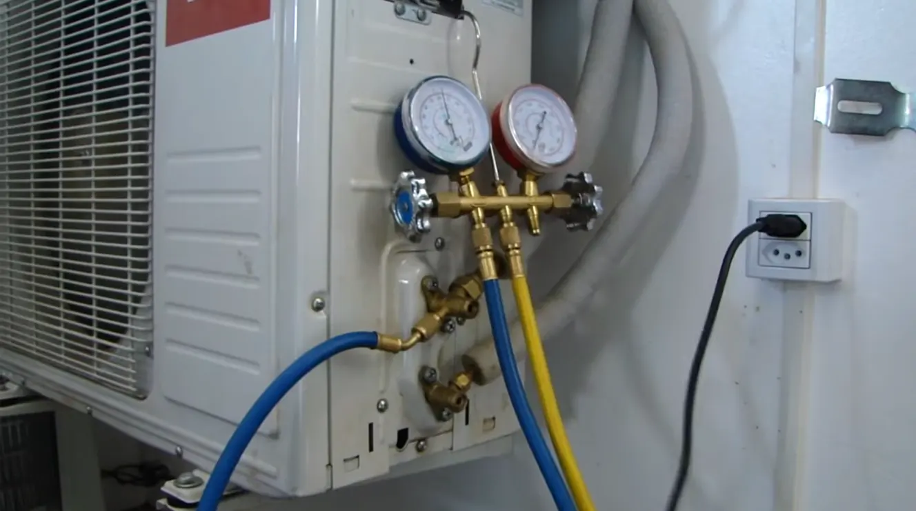 Técnico utilizando manômetro para carga de gás em ar-condicionado